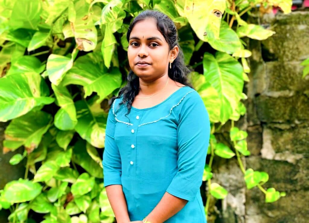 Photo: VILUTHU A girl in a blue dress standing in front of a tree.