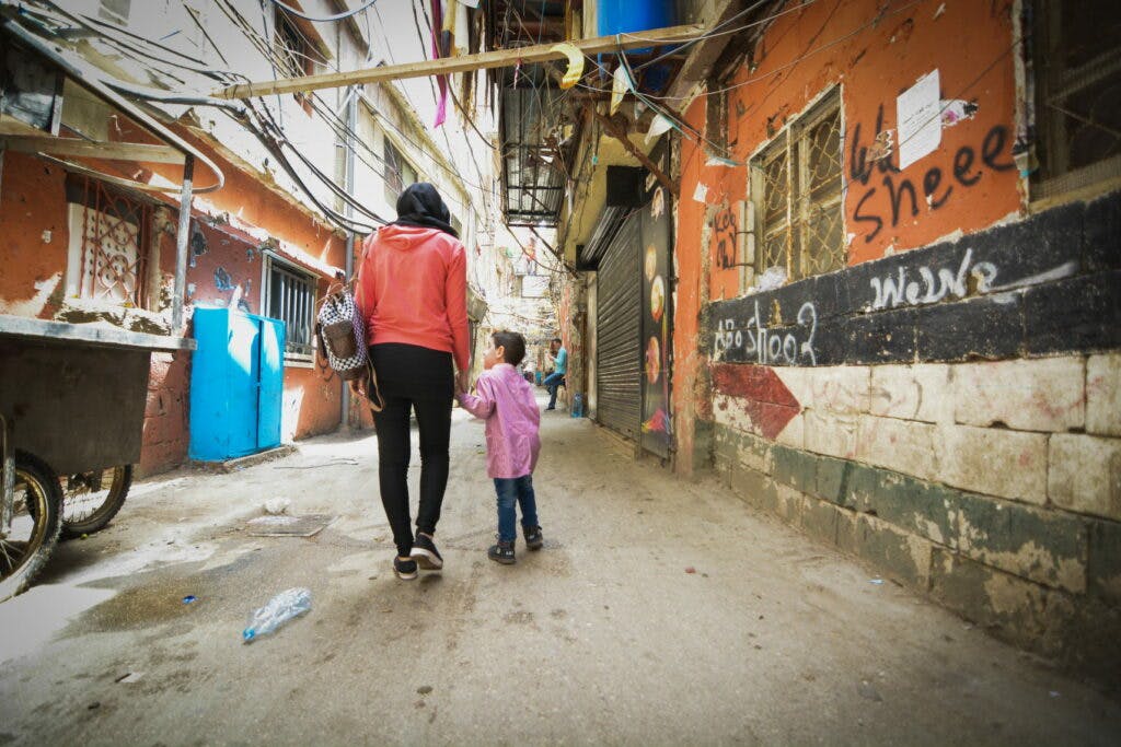 A woman and a child walking through a street.