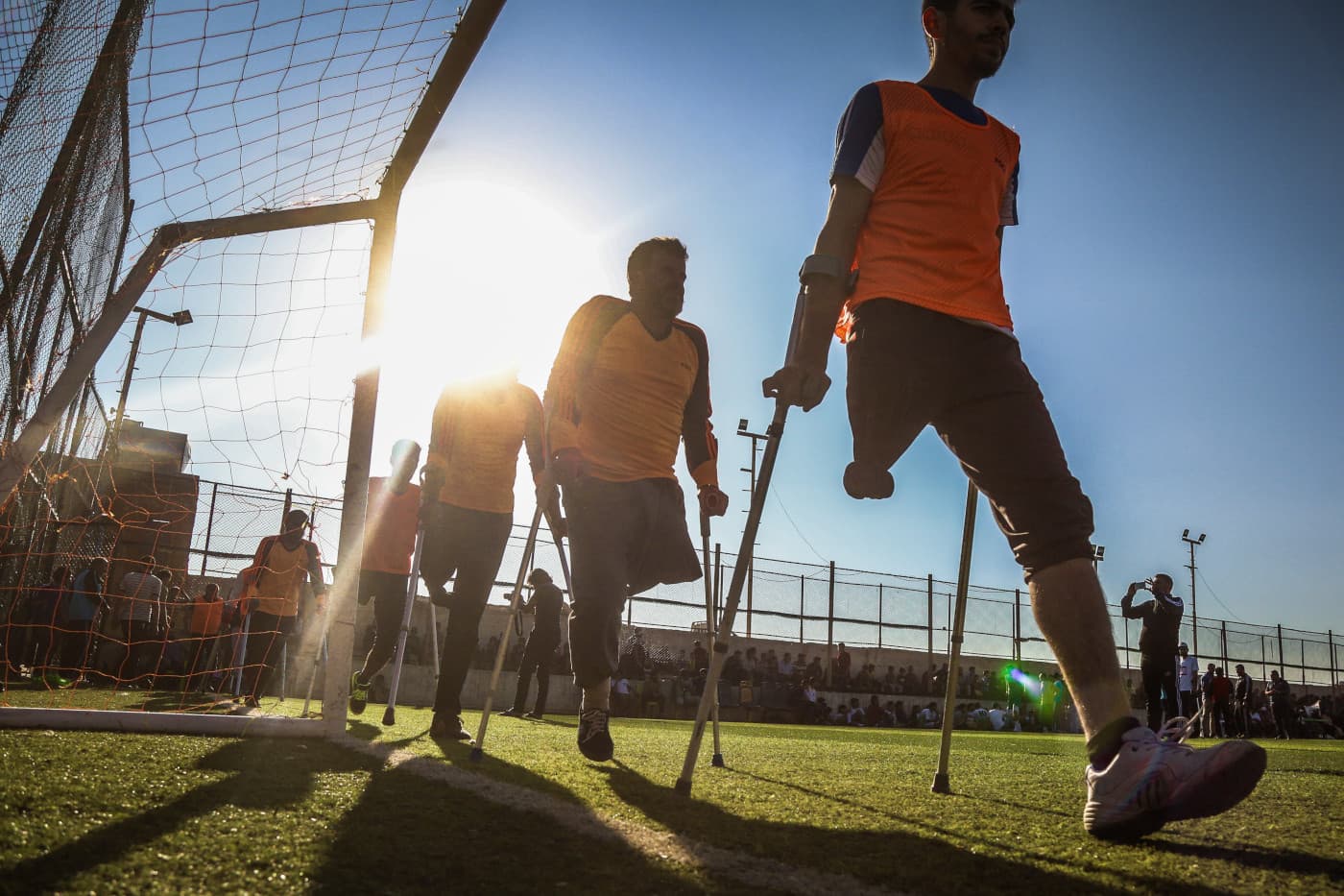 A group of football player with crutches on a field. A group of football player with crutches on a field.
