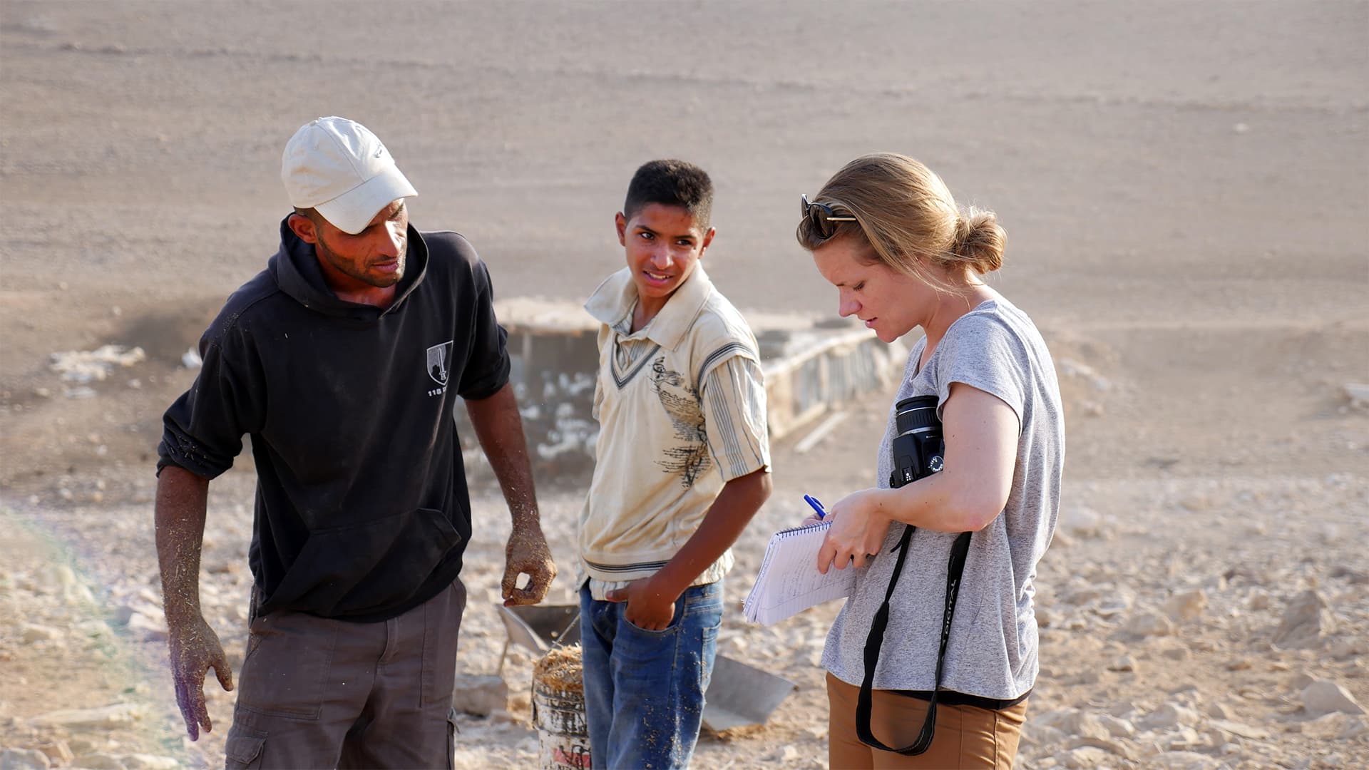 Foto: Diakonia Kvinnlig reporter intervjuar två män i ökenområde.