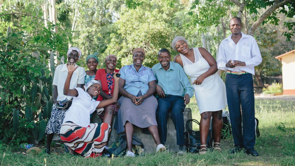 Photo: Anna Hugosson A group of Zimbabwean men and women outside in a green field with trees in the background.