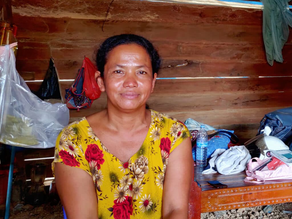 Photo: Diakonia A woman sitting in a house with a wooden panel in the background.