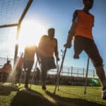 A group of football player with crutches on a field.