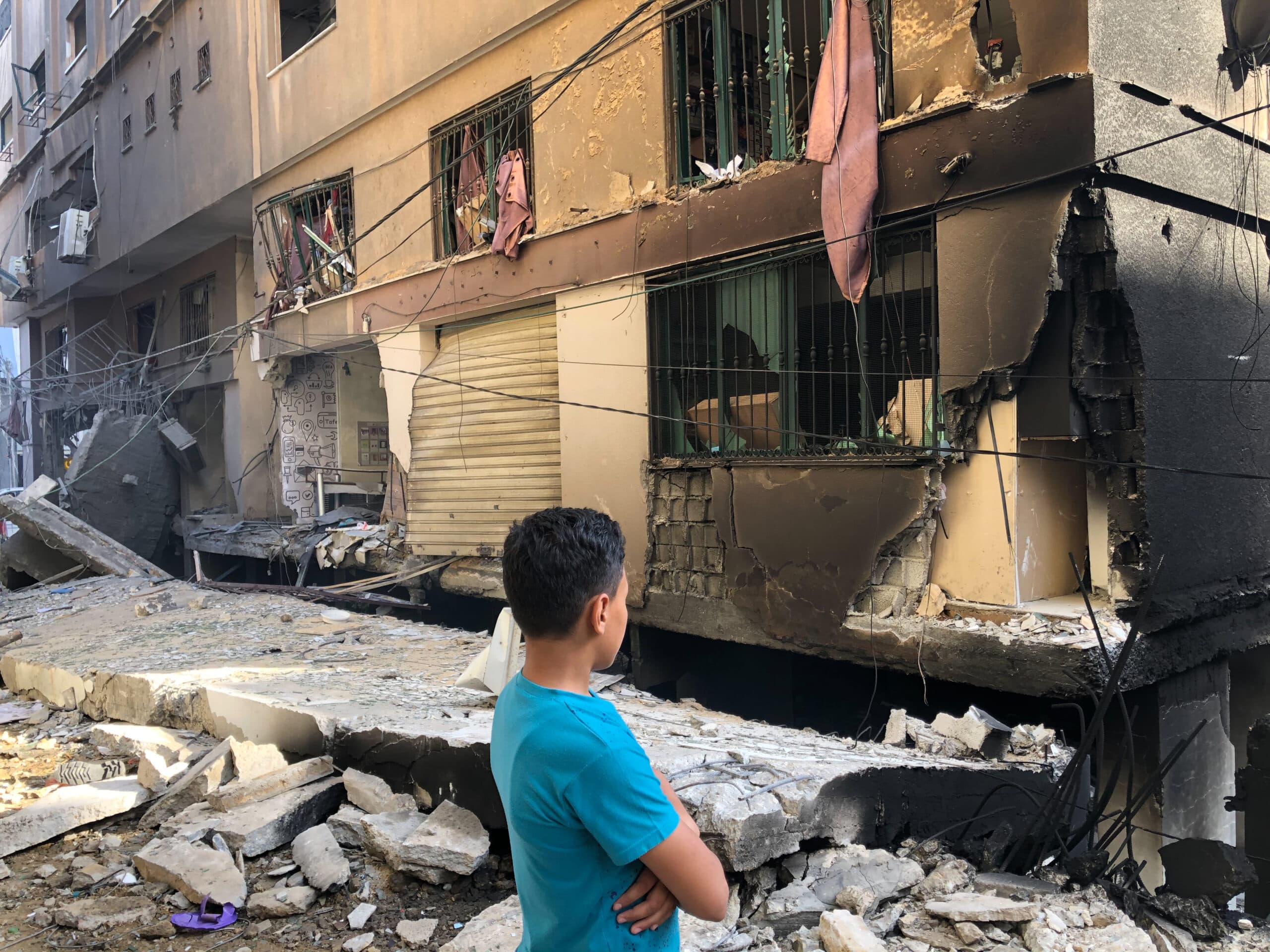 A man in front of a building looking at the damaged caused by an explosion. A man in front of a building looking at the damaged caused by an explosion.